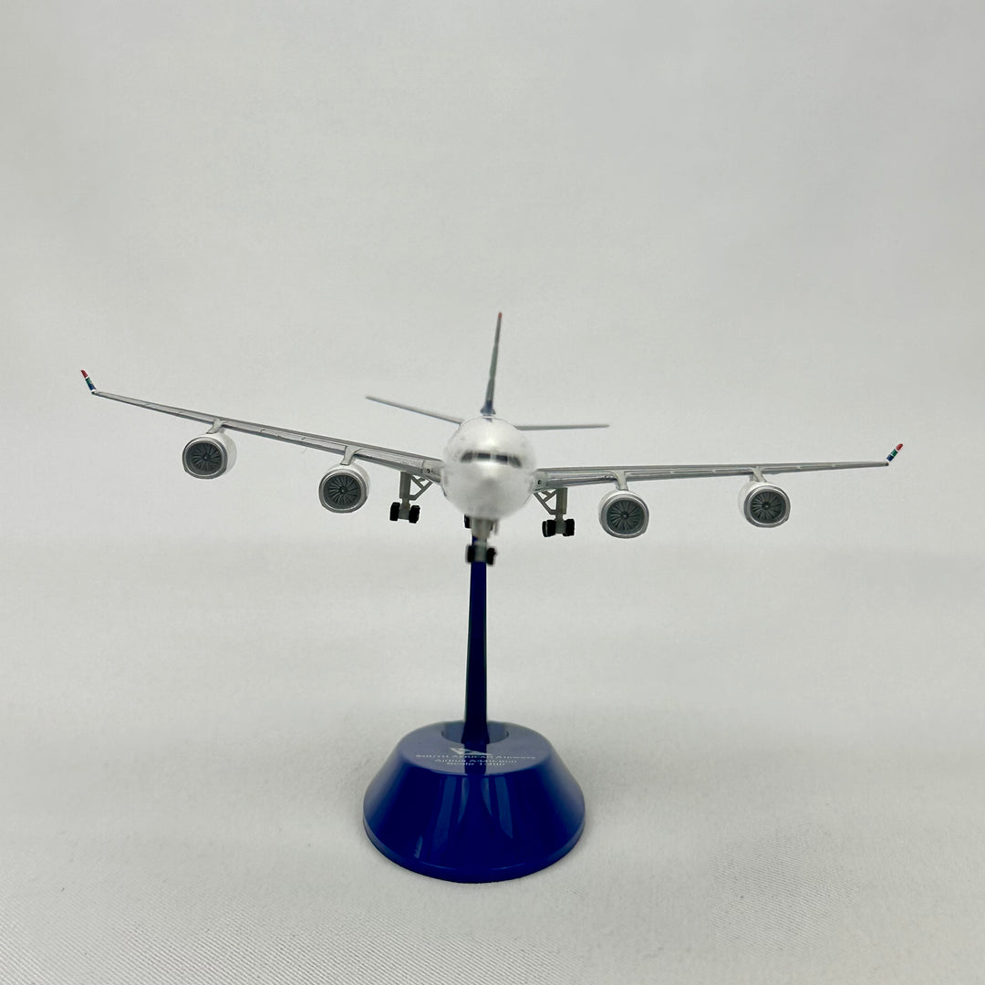 Model airplane on a blue stand against a white background